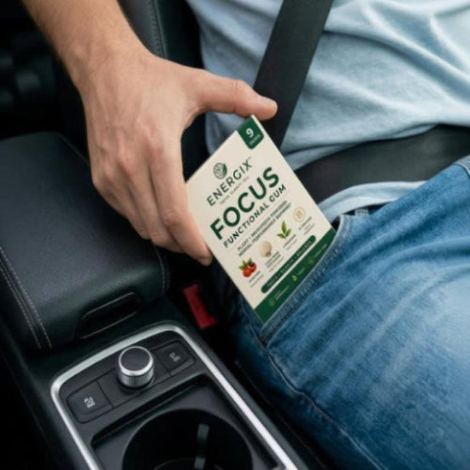 Person holding a box of Energix Focus Functional Gum in a car.